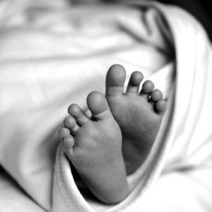 Newborn feet with baby in a swaddle